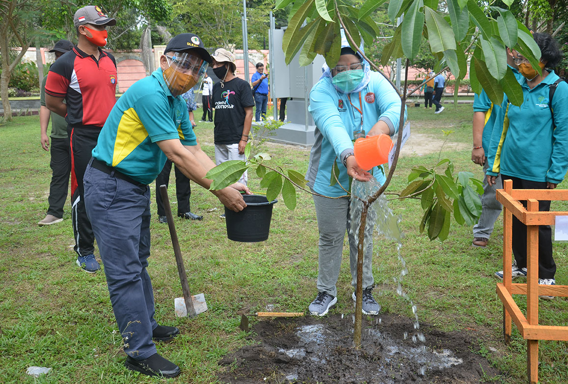 Bupati Kobar didampingi Kepala DLH sedang menyiram tanaman Bintaro (Cerbera Mangas)